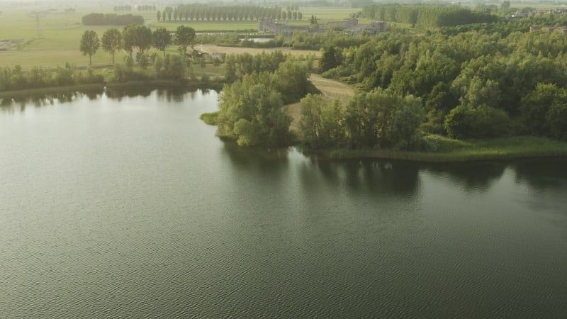 Aerial view of a lake shore with industrial buildings in the background