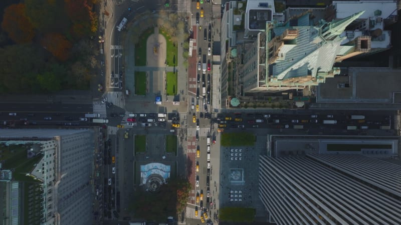 Aerial birds eye overhead top down descending footage of traffic in streets and crossroads around Central park. Pulitzer and Grand Army Plaza from height. Manhattan, New York City, USA