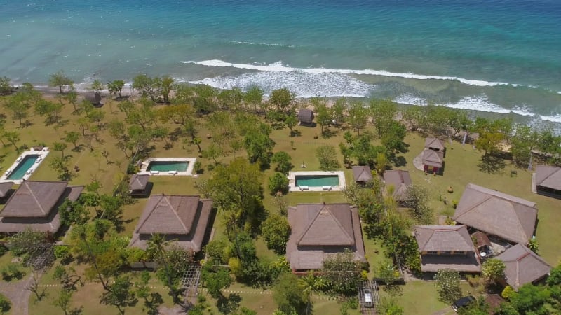 Aerial view of luxury bungalows near the coast of Bali island.