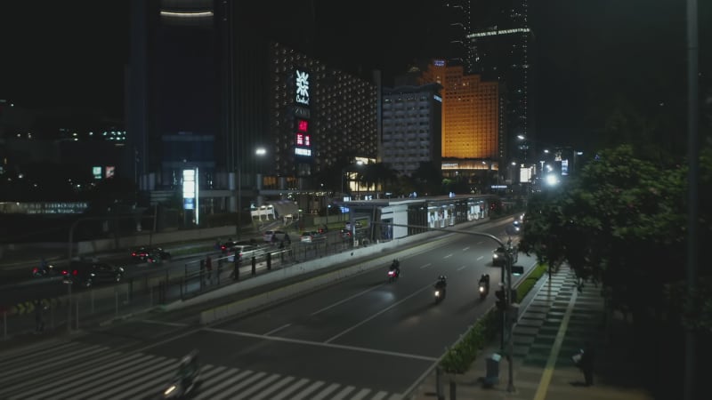 Aerial cinematic rising shot of busy multi lane highway traffic at night from street view to aerial view of busy traffic in Jakarta