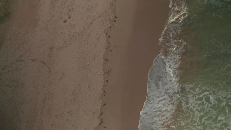 Aerial view of waves breaking on the beach in Cornwall, United Kingdom.