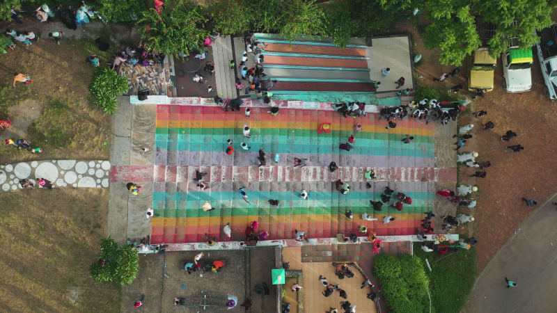 Aerial view of people walking up and down a colourful stairs.