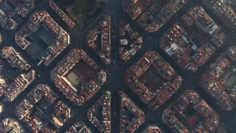 Vue aérienne d'un drone de Barcelone montrant des pâtés de maisons typiques sous un soleil magnifique avec la circulation urbaine