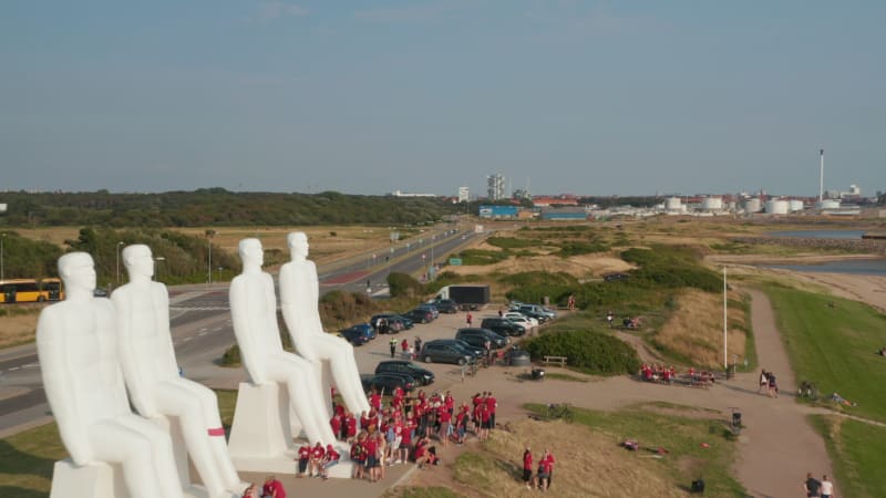 Aerial view flying near Man Meets The Sea, a colossal monument on Esbjerg coastline in Denmark. Drone view flying over the giant landmark visited by numerous tourists