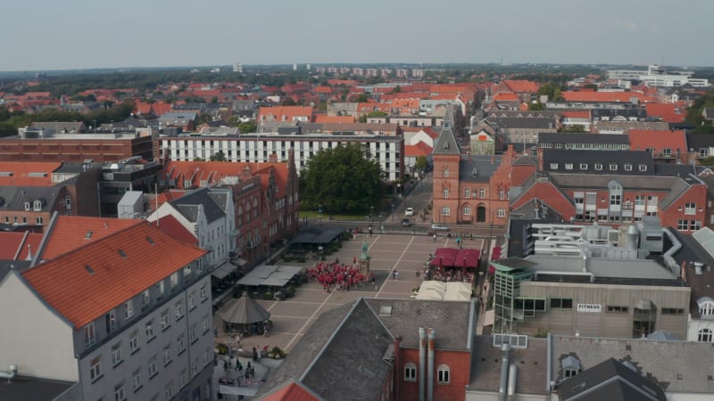 Aerial Dolly over the famous Torvet square in Esbjerg, Denmark with town hall and the statue of Christian IX. Drown view showing Torvegade street, one of the longest pedestrians streets in Denmark