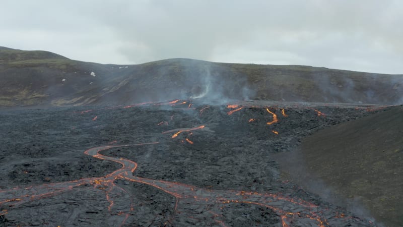 Active lava field with flowing lava and dark volcanic landscape