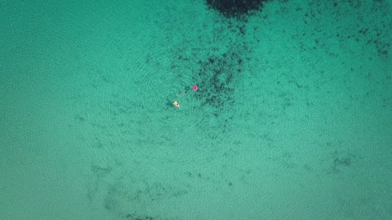 High aerial view of two young girls swimming and playing.