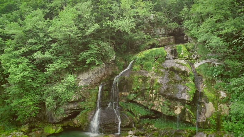 Aerial view of a waterfall surrounded by rocks and nature nearby.