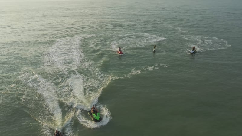 Aerial view of people riding jet ski in open water.