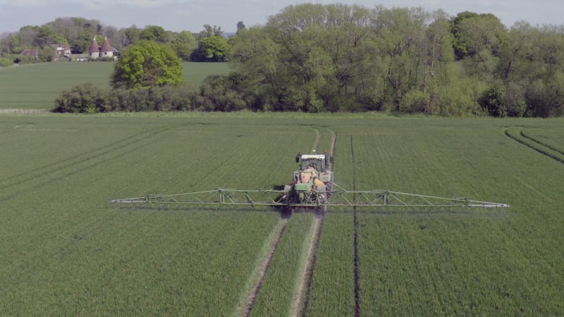 Tractor Spraying a Controversial Glyphosate Herbicide on Agricultural Land