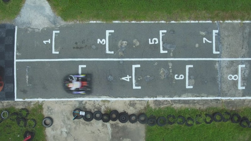 Aerial view of a group starting to drive kart on a speedway.