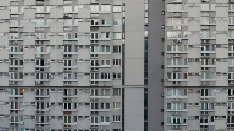 Sliding reveal of large apartment building on housing estate. Full frame of wall with windows. Warsaw, Poland