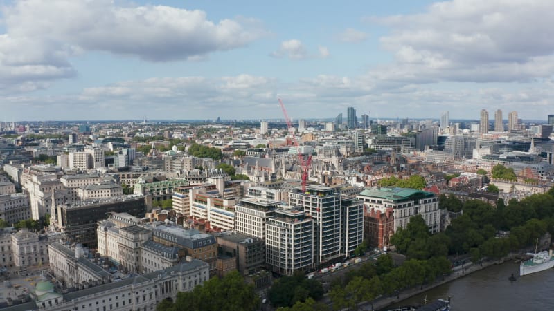 Panorama curve footage of buildings in city district. Aerial view on old houses, Historic Royal Courts of Justice buildings complex. Modern skyscrapers in background. London, UK