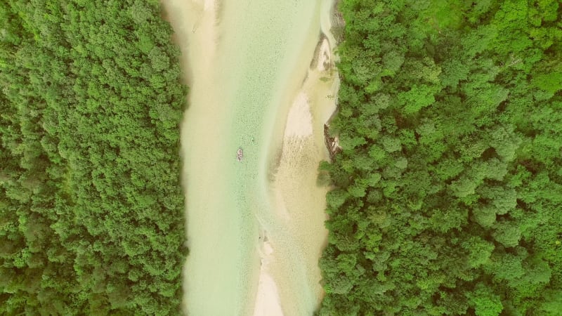 Aerial view of a group of people doing white water rafting on rapids.