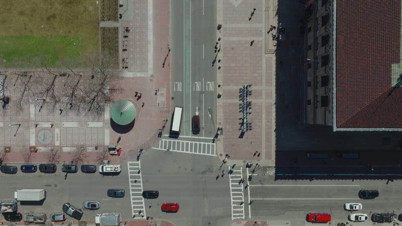 Bird's eye shot of traffic on streets in town. Vehicles moving on road and pedestrians walking on pavements and crosswalks. Boston, USA