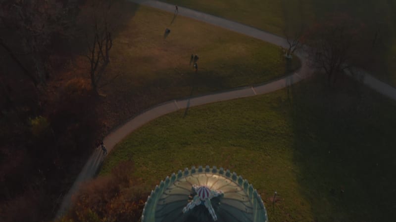 Scenic Aerial Birds Eye Overhead Top Down View above The Monopteros in English Garden in Munich, Germany tilt up revealing Cityscape in stunning winter haze