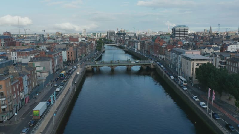 Descending forwards fly above Liffey river near Grattan Bridge. Traffic jam on embankment roads. Dublin, Ireland