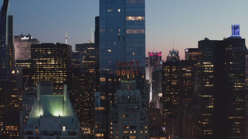 Scenic View of City Nightlife with bright flashing lights in Skyscraper Urban Canyon after Sunset in New York City, Aerial Wide Shot