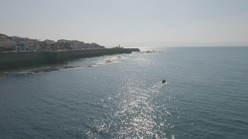 Aerial view of a person doing kayak along the shore, Old City of Acre, Israel.