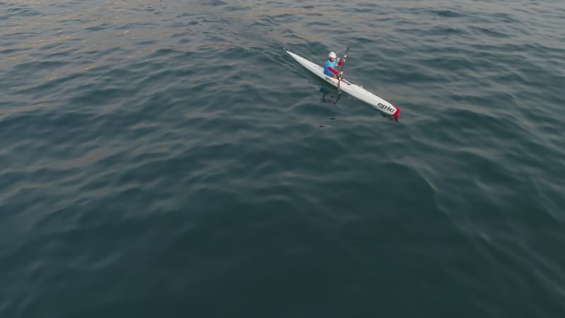 Aerial view of a man paddling kayak mediterranean sea.