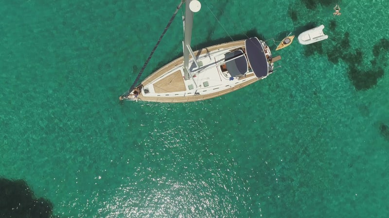 Aerial view above of single sailboat anchored in the mediterranean sea.