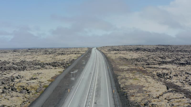 Drone view flight towards Ring Road, highway route no. 1 in Iceland. Cars driving peacefully on the main road with stunning landscape