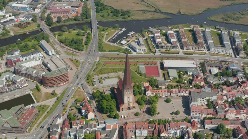Tilt down aerial shot of Saint Peters church. Old and famous religious building with tall and pointed spire. Traffic on multi lane road leading around
