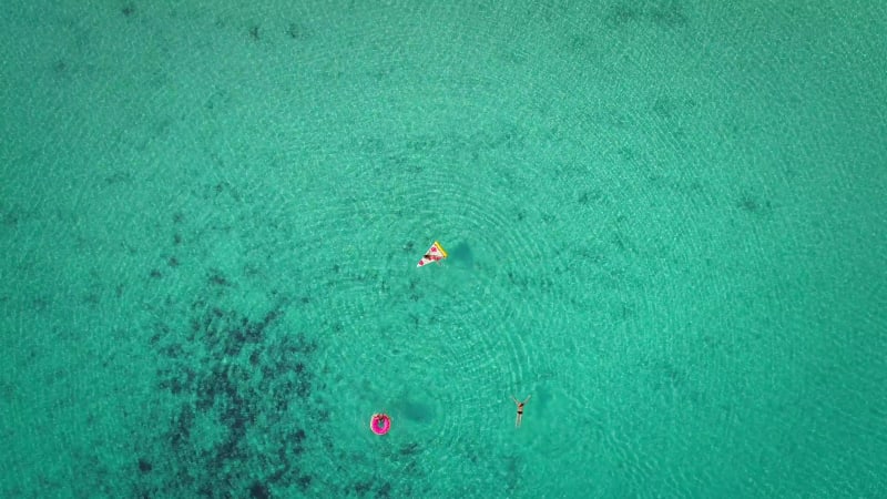 High aerial view of two young girls swimming and playing.