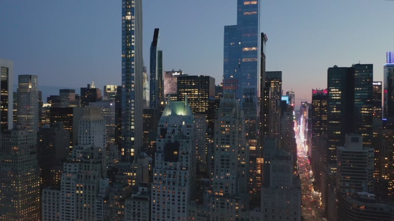 A big city Skyline at Night with lit up Streets and Intersections with Rush Hour Car Traffic, Aerial Drone View from above