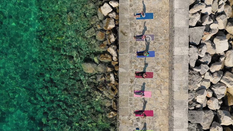 Aerial view of group practicing yoga at artificial pier, Veli Lošinj.