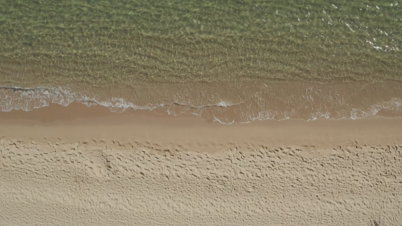 Beautiful Generic Tropical Beach Overhead Shot, bird's eye view of ocean waves crashing against an empty beach from above