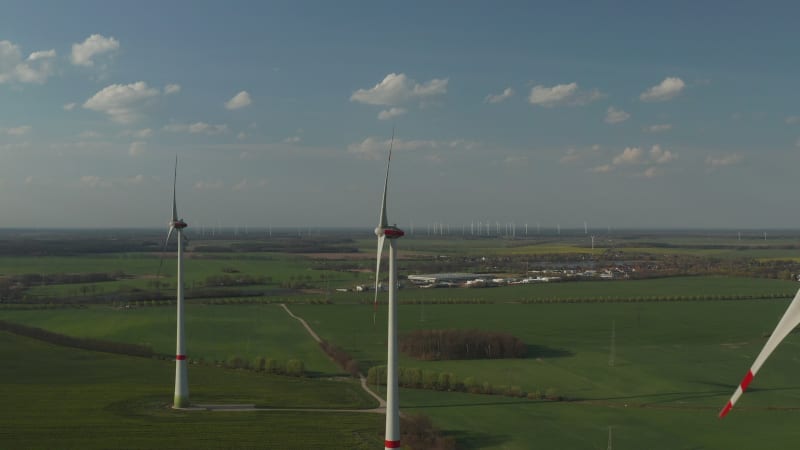 View of Windmills Farm for Energy Production on beautiful Blue Sky Day with Clouds. Wind power turbines generating Clean renewable energy for sustainable Development