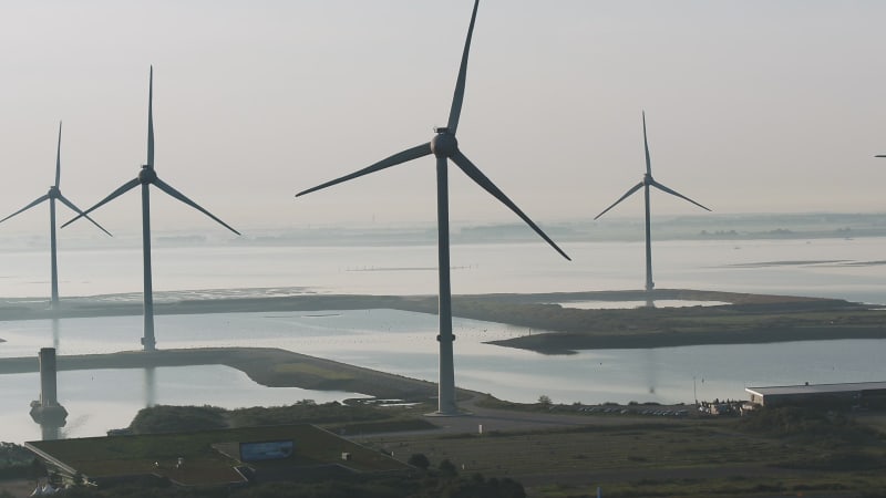 Aerial von Windmühlen, die sich an einem bewölkten Tag durch die Windkraft drehen