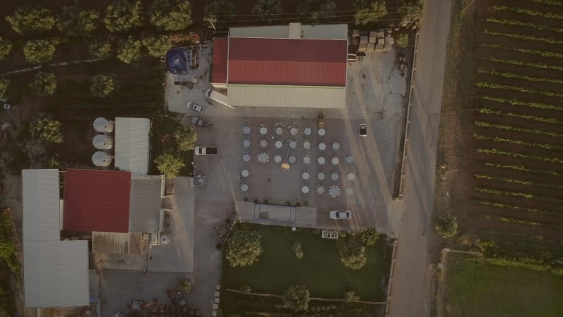 Aerial view of people preparing tables and chairs for a outdoor party.