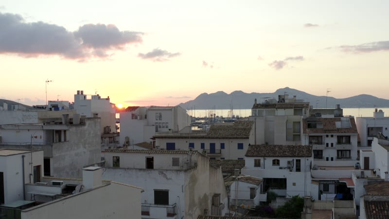 AERIAL: Small City with Port on Tropical Island with Boats and Ocean at Small Town at Sunrise with Mountains in Background Vacation, Travel, Sunset