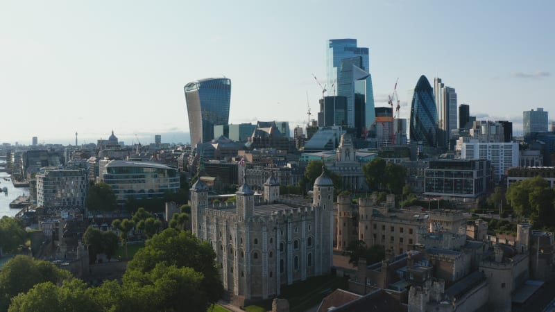 Fly around historic Tower of London with view of downtown skyscrapers in City financial hub. London, UK