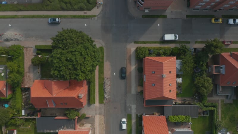 Aerial birds eye overhead view of Esbjerg, Denmark. Top down slow flight view pedestrian strolling down the road and car parked in parking lot