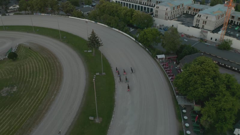 Tracking Shot of Horse Race on dirt track galloping fast, Aerial Birds Eye View