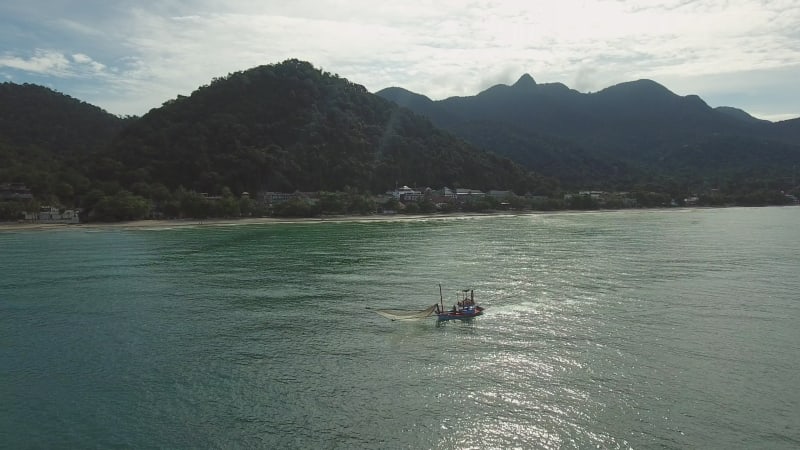 Aerial view of small fishing boat navigating on calm water, Ko Chang.