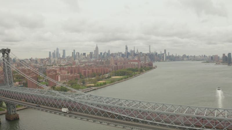 Flight over Williamsburg Bridge Brooklyn side with Car traffic and streets at cloudy day