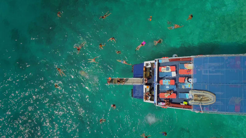 Aerial view of people in ferry diving on the sea, Ithaki island.