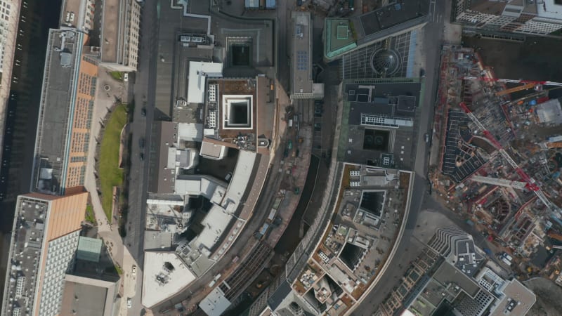 Overhead top down aerial view of house rooftops near construction site in Hamburg city center. Rows of houses and apartment buildings