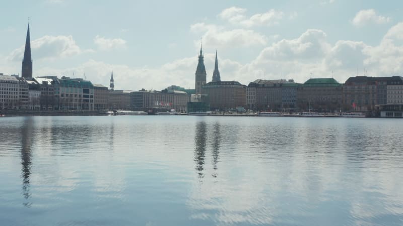 Flying over water surface of Binnenalster lake towards Hamburg city center with town hall