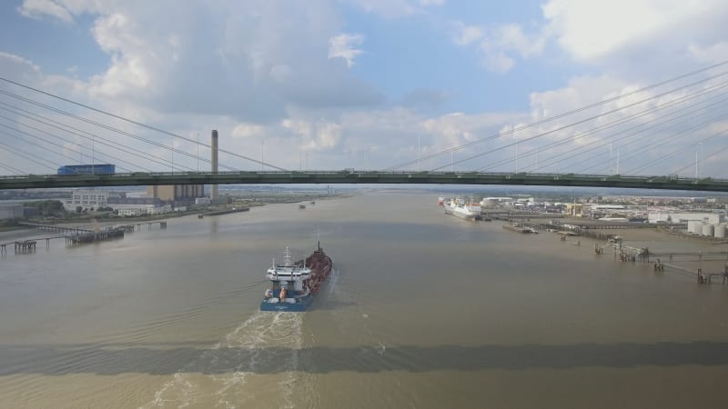 Large Ship Travelling Under Suspension Bridge