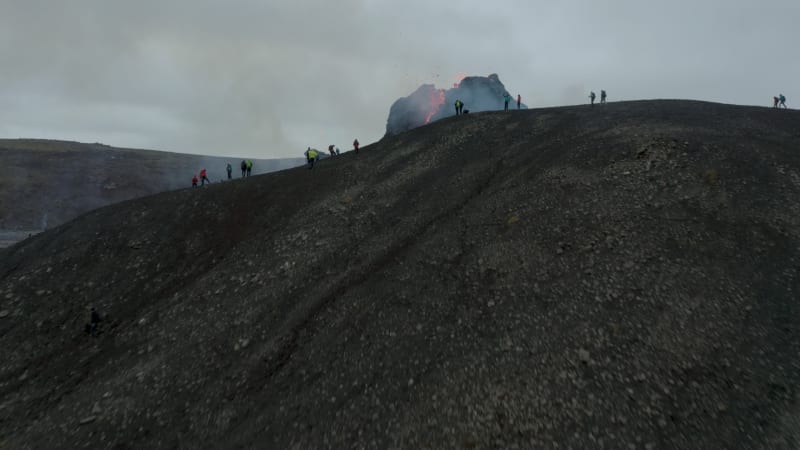 People on the mountain side watching the volcanic eruption in Iceland