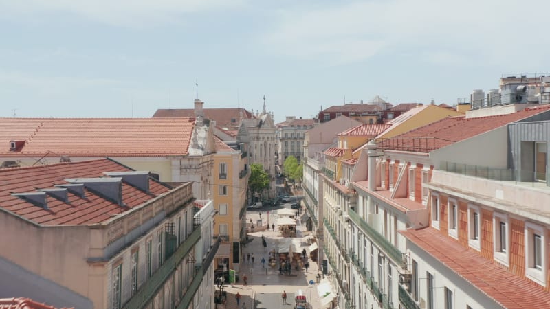 Close up aerial orbit of Sanctuary of Christ the King statue on the hill with reveal of Ponte 25 de Abril red bridge in Lisbon, Portugal