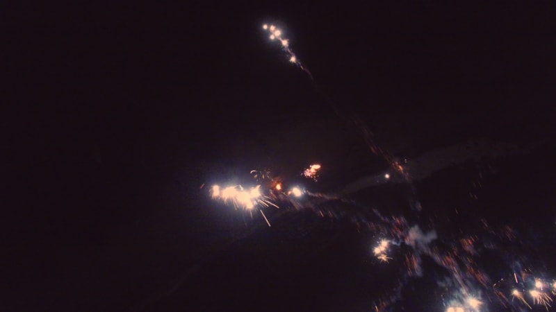 Aerial view of fireworks in a night sky on a beach.