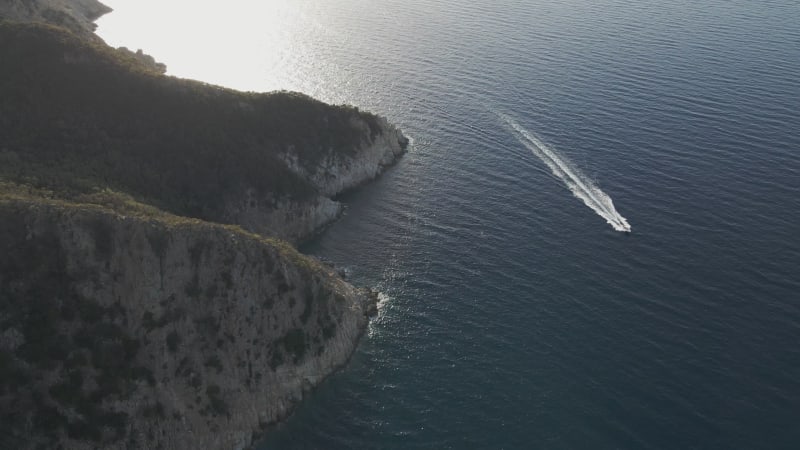 Aerial view of a motorboat sailing along the coastline in Marciana Marina, Elba Island, Italy.