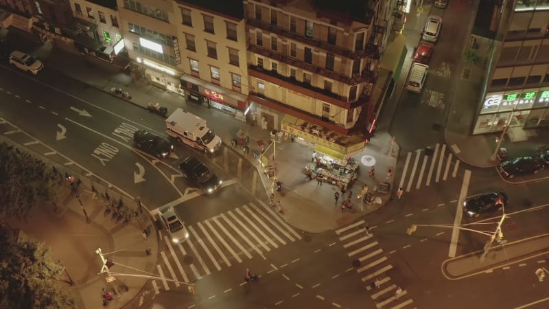 Establishing Overhead Top Down Shot of Road Intersection with Car traffic and Street Food Market  at Night in Chinatown, Manhattan, New York City