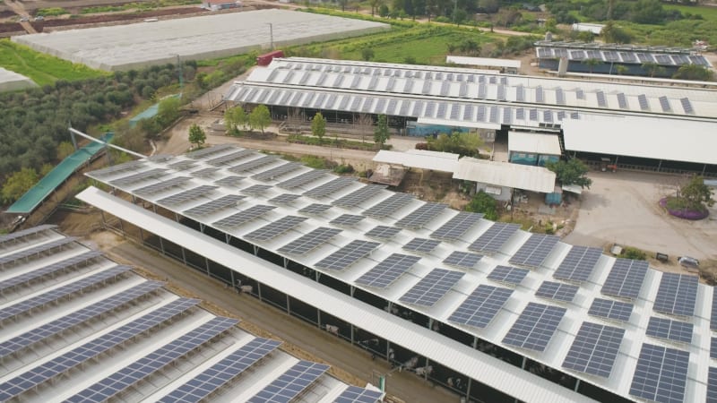 Aerial View of solar panels on the roofs of industrial buildings, Nir David.